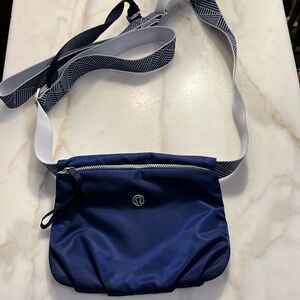 Lululemon yoga mat carrier with Navy blue zippered pouch.